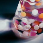 a beaker filled with colorful beads floating in clear liquid