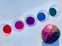 photo of a purple cabbage and five small cups of water, each with a different color ranging from red to blue to green